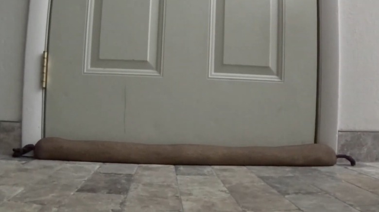 A draft blocker in front of door made from old tights