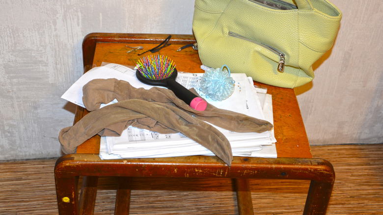 A hairbrush sitting next to tights on a table