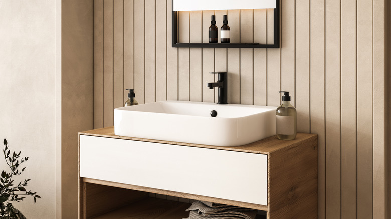 A tan bathroom with modern accessories.