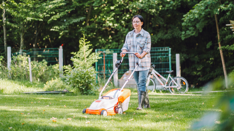 Woman mowing the grass in her lawn