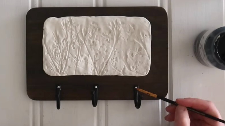 Wall mounted key rack made out of a Dollar Tree cutting board hanging on the wall.