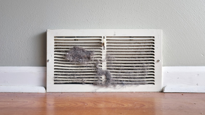 Dirty air vent clogged with hair, dust, and debris.