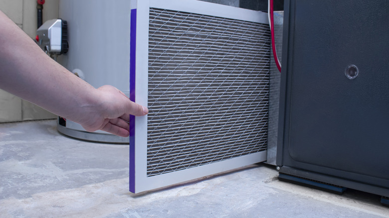 A person changing a furnace filter