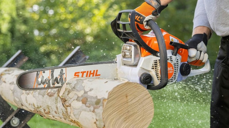 Person using the Stihl MS 162 to cut a log