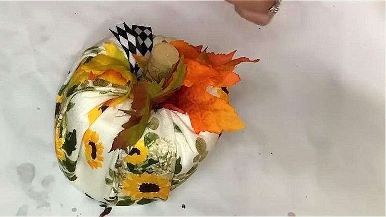 Toilet paper roll wrapped in floral fabric with autumn leaves