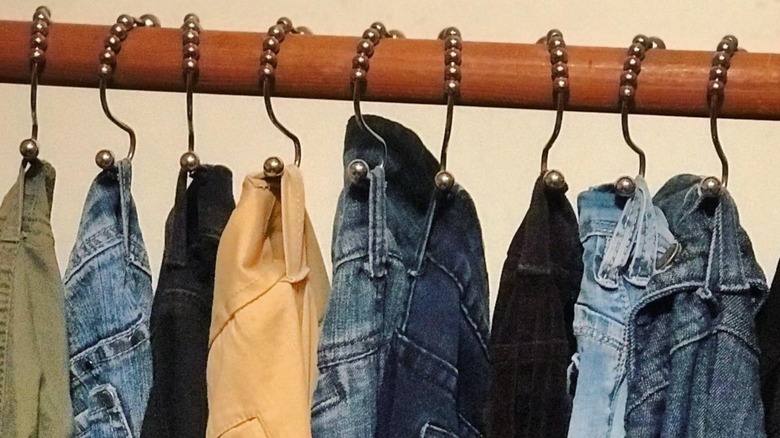 Metal shower rings slotted through belt loops on pants and hung on closet rail