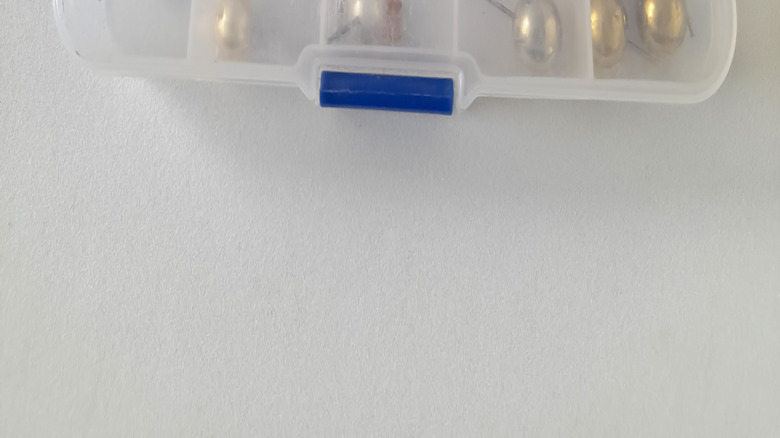 Close up of clear compartment organizer filled with jewelry pieces