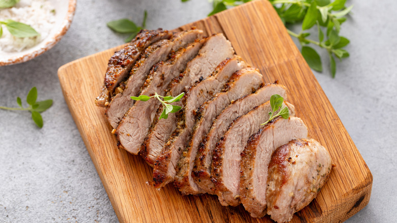 Cutting board with meat on it