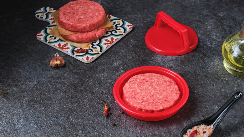 hamburgers being made in a patty press