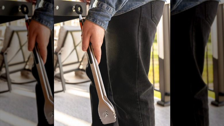 Blackstone Signature Stainless Steel Tongs being hung on a grill
