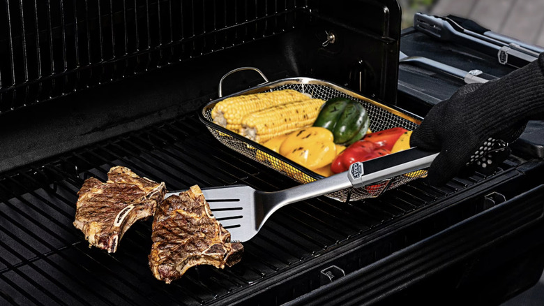 Stainless steel spatula flipping steak on the grill