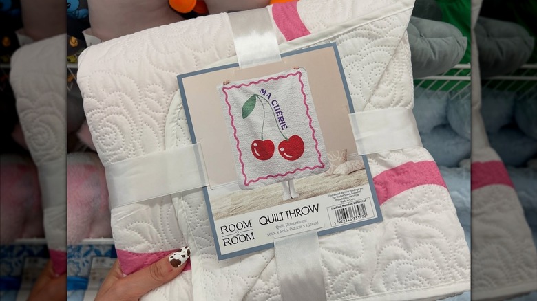 A quilt with a cherry print and the words "ma cherie"