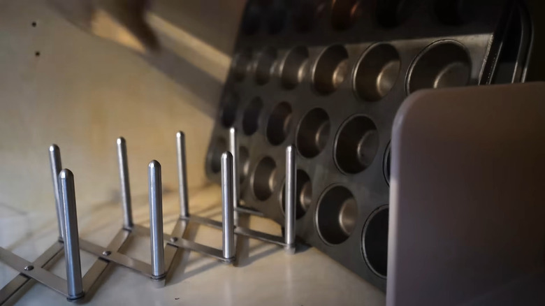 IKEA pot lid organizer holding baking sheets and muffin tins