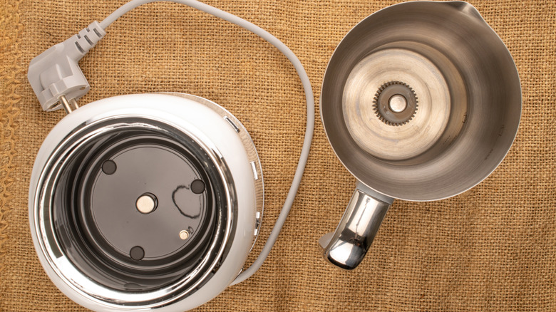 Person using a milk frothing machine