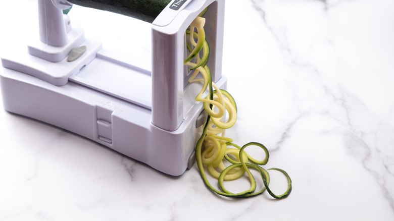Spiralizer machine being used to make zucchini