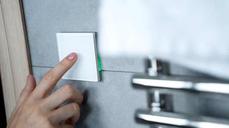 hand pressing square touch panel light switch