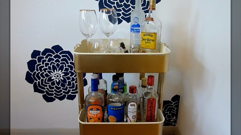 IKEA cart turned into bar cart with glasses on top and drink bottles on bottom