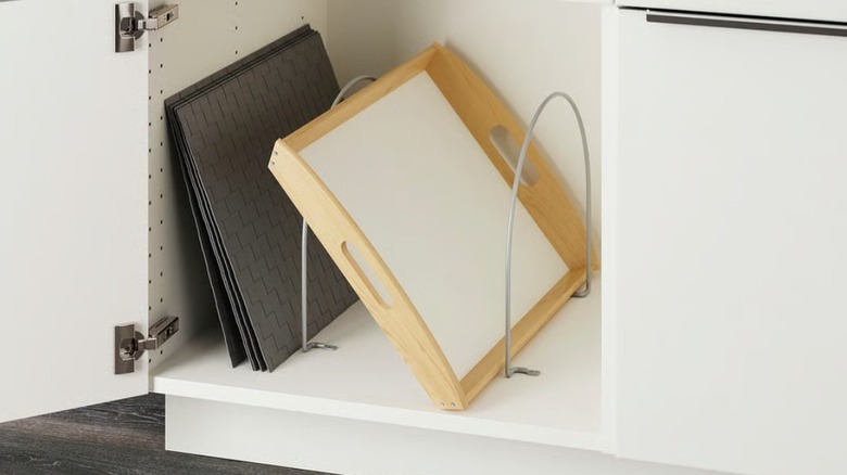 Baking trays and food tray organized in kitchen cabinet on partition
