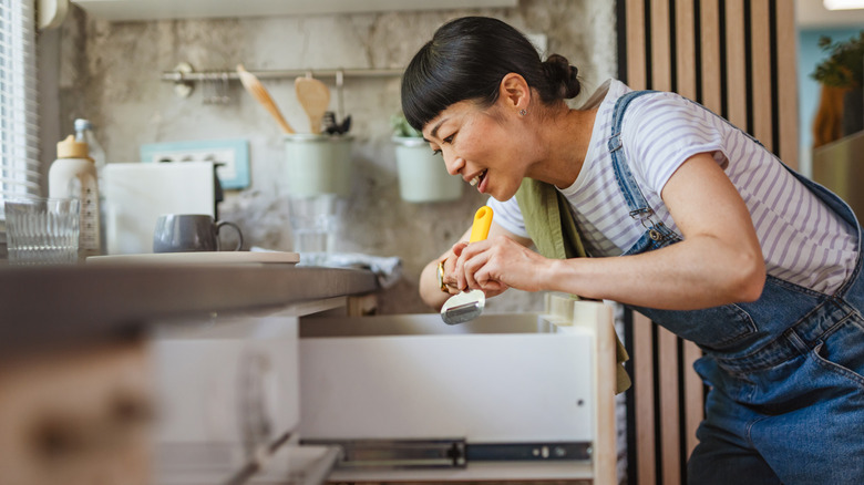 A person organizing kitchen drawers
