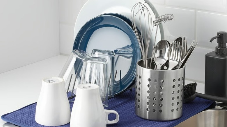 Drying utensils and dishes on white kitchen countertop