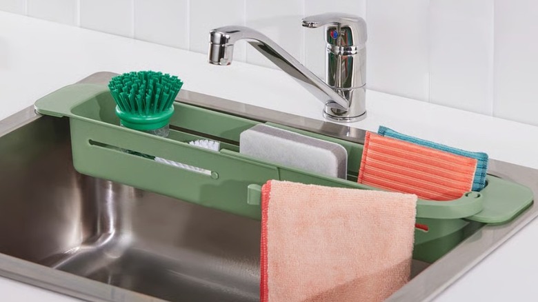 Green sink organizer with dish cleaning spplies