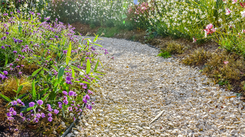 Gravel walkway with rubber edging and flowers along the border