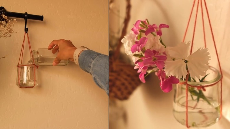 Woman filling hanging flower glass vase with macrame string
