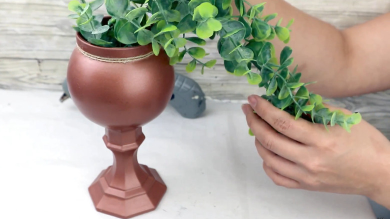 Copper goblet-style planter with artificial plant that is made of candleholder and glass vase