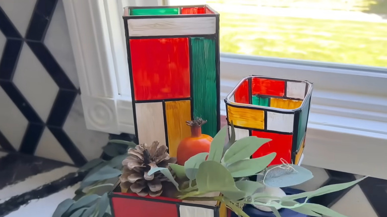 Stained glass style square vases beside window with accessories