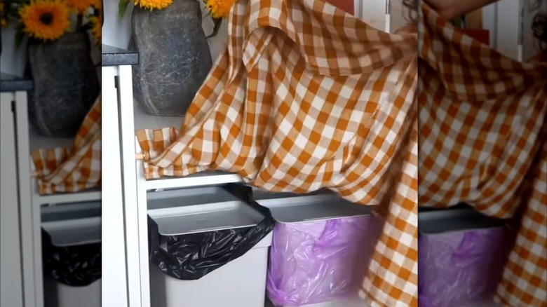 Hidden trash cans behind DIY curtain attached below kitchen table
