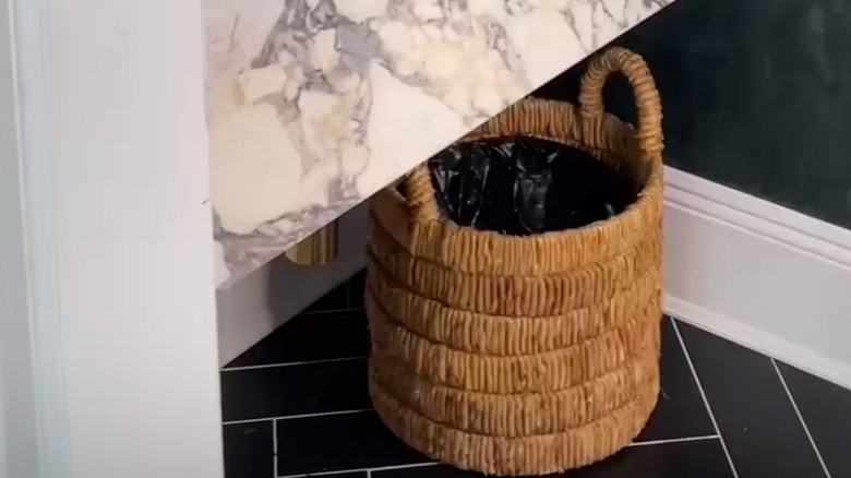 Wicker basket used as trash can below bathroom sink