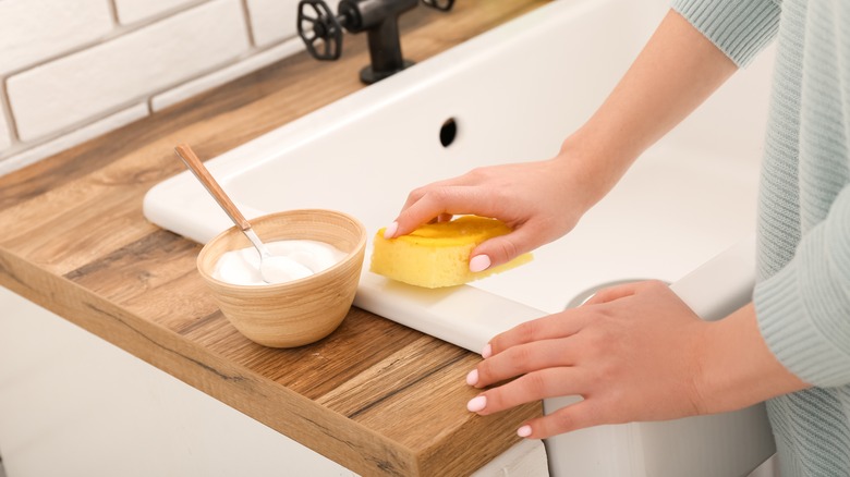 woman cleaning rustic sink with baking soda