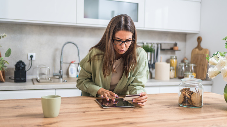 A woman with her credit card and iPad.