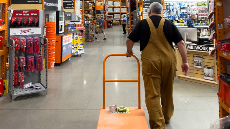 A man rolling a platform through Home Depot.