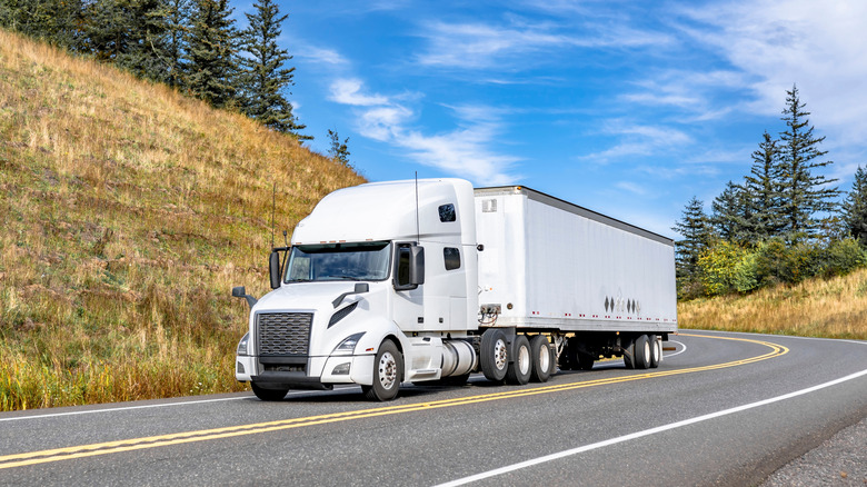 A big white delivery truck on a rural road.
