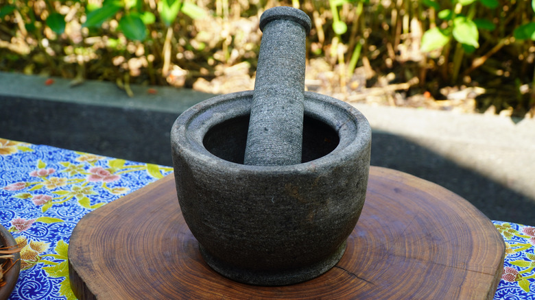 Clean stone mortar and pestle on wood stand outside
