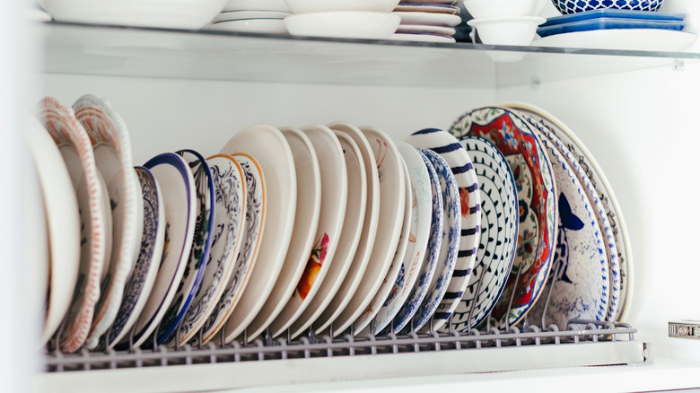 Colorful vintage plates in organizer in cabinet