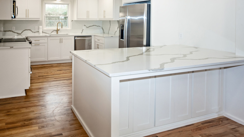 a white kitchen with quartz countertops