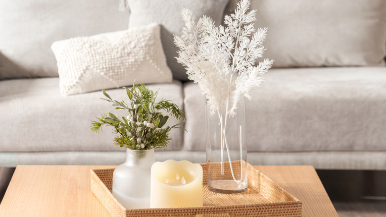 Glass vases on a tray in front of a beige couch