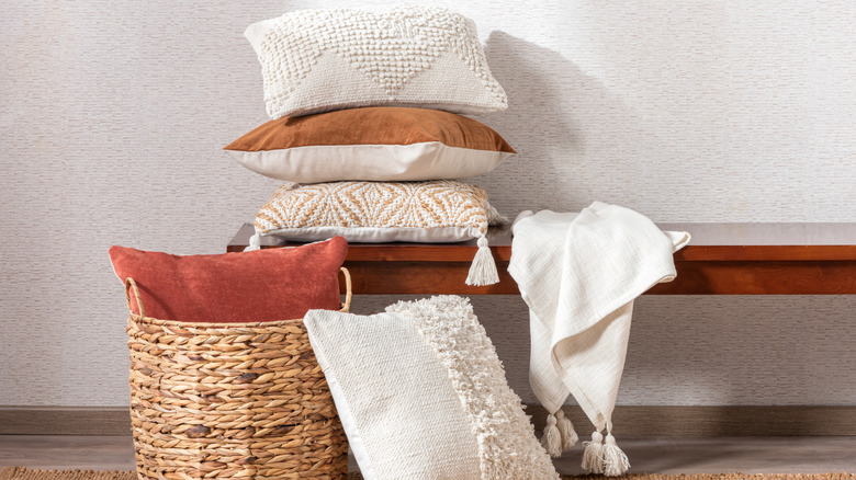 stack of throw pillows on a bench