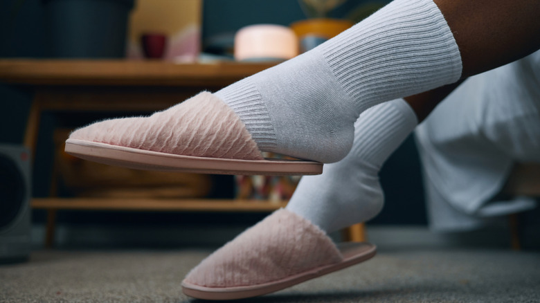 close up of feet wearing socks with slippers