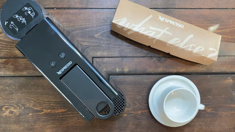 The mini espresso maker by Breville in black finish on a wooden table