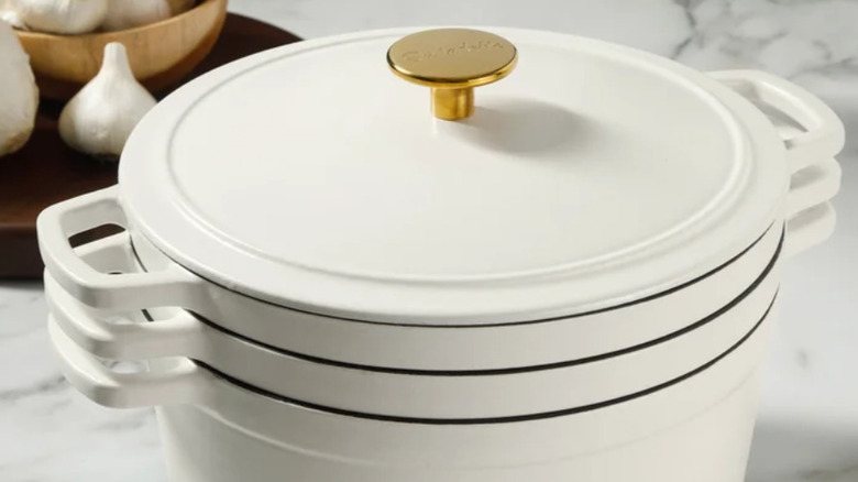 The stackable cast iron cookware in a white finish sitting on a countertop.