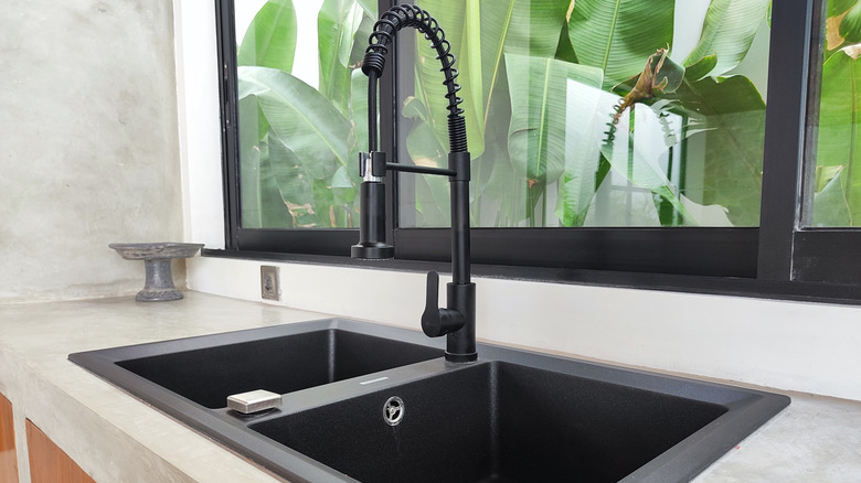 Kitchen with concrete counters and a matte black sink
