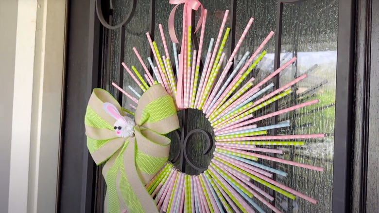 Spring holiday wreath made of plastic straws hanging on front door
