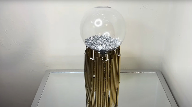 Glass sphere atop gold painted straws for home decor