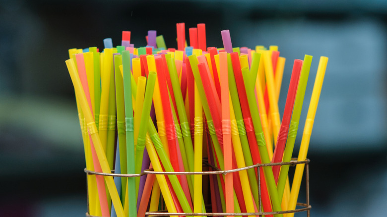 Plastic drinking straws arranged in wire holder
