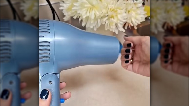 person using blue hair dryer to dry nail polish