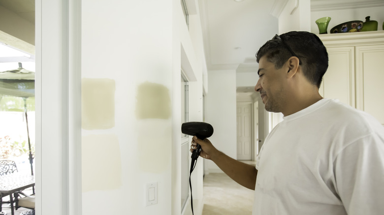 man drying paint with hair dryer