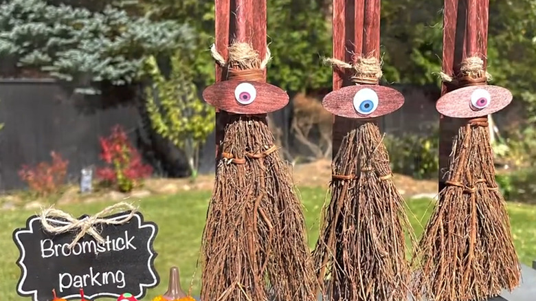 Mini cinnamon brooms with eyes glued to them lined up next to Broomstick Parking sign